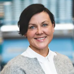 En kvinne som smiler til kameraet