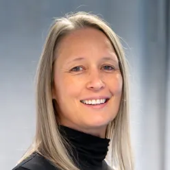 Kvinne smiler til kameraet