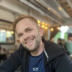 En mann som smiler til kameraet