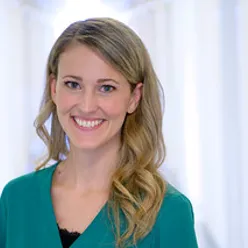 Kvinne smiler mot kamera